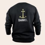 Black personal sweater printed with a gold anchor and the name Daniel
