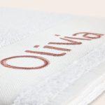Close-up of a white bath towel embroidered with the name Olivia in rose gold thread. Create something special with a personalised white bath towel.