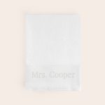 Personalised white bath towel embroidered with Mrs Cooper in light grey thread