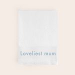 Personalised white bath towel embroidered with the text Loveliest mum in blue thread