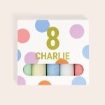 Personalized chalk box with a large number 8 and the name Charlie printed on the front, showing colorful chalk sticks
