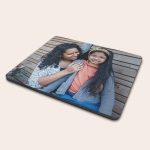 Rectangular personalized photo mouse mat printed with a mother and daughter smiling on a wooden background.