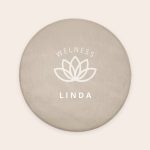 Round personalized bath mat in beige with WELNESS, a lotus flower, and LINDA printed in white.