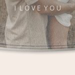 A close-up of a personalized bath mat with a printed "I LOVE YOU" message over a soft fabric.