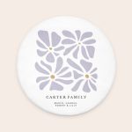 Round personalised bath mat with a printed purple floral pattern and custom text "CARTER FAMILY" and "MARCO, HANNAH, ROBERT & LILLY"