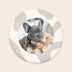 Round personalized bath mat printed with a photo of a French bulldog puppy hugging a teddy bear to create a personal haven