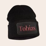 Black beanie with the name Tobias embroidered in red script on a black patch