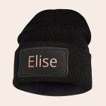 Black knit beanie with embroidered name Elise in pink on a black rectangular patch
