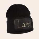 Black knitted beanie with an embroidered name Lars in light gold thread on a black patch