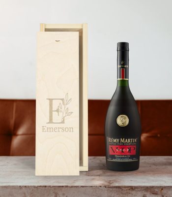 Rémy Martin VSOP brandy bottle next to a personalized wooden case engraved with "Emerson" and an E initial