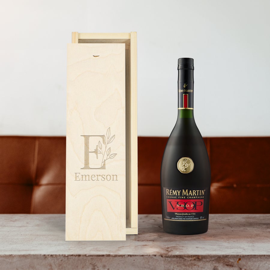 Rémy Martin VSOP brandy bottle next to a personalized wooden case engraved with "Emerson" and an E initial