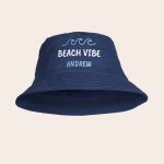 Navy personalised bucket hat with the printed text "BEACH VIBE" and name Andrew below three wave icons