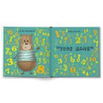 Open children's book with a bear character and colorful numbers, personalized with text 'YOUR NAME' to celebrate being 2