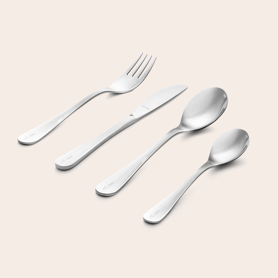 Personalised children's cutlery set - Engraved, showing a shiny silver fork, knife, large spoon, and small spoon, each handle engraved with a custom name