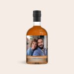 Bottle of dark rum with a personalized label, printed with a photo of a smiling couple