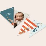 A personalised garland - Triangle - M - 5m with three custom-printed flag designs: a baby photo, an elephant, and a giraffe with the name Evie and the word Welcome