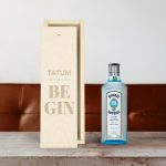 Bombay Sapphire gin bottle next to an engraved wooden case with the text Tatum Let the Party Begin, personalized with a name and message