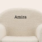 Off-white personalised kids teddy chair with the name Amira embroidered in black text.