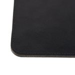 Close-up of a black personalized leather mousepad with subtle texture and stitched edges