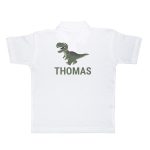 White kids polo shirt printed with a green dinosaur graphic and the name Thomas below it
