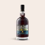 A Graham's 10 Years Cask Matured port bottle with a custom photo label showing a gym interior and text Cheers a new location.
