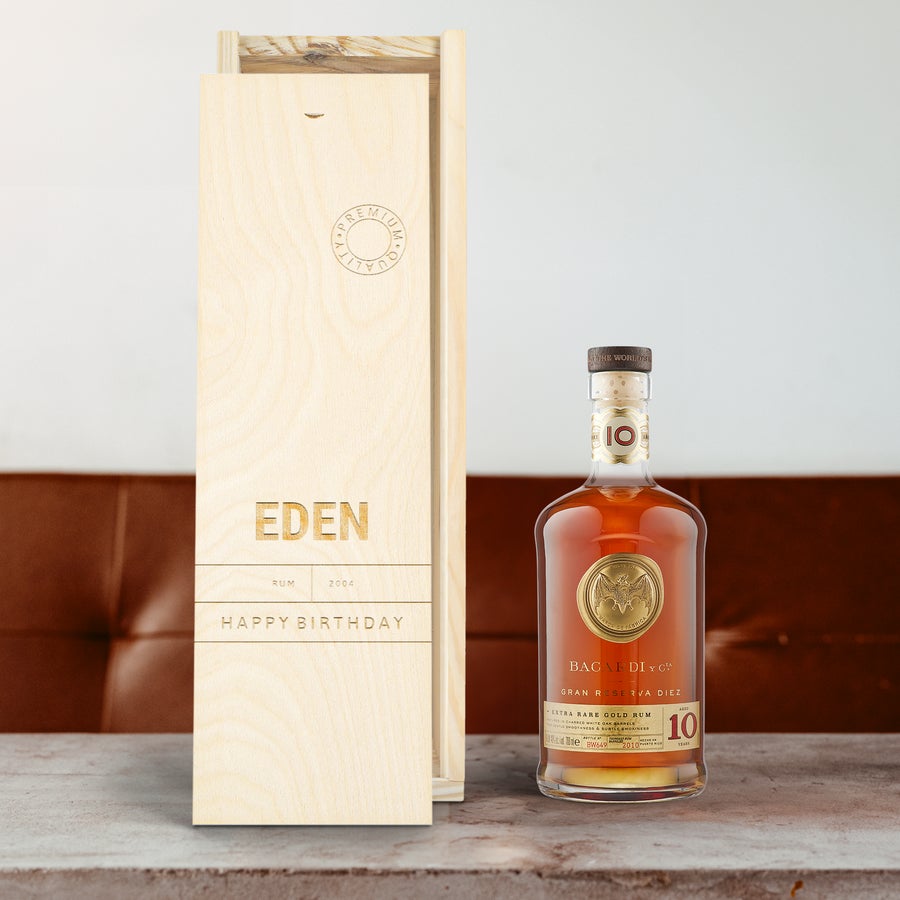 Bacardi Reserva Diez rum bottle next to an engraved wooden case personalized with a name and Happy Birthday