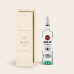 A bottle of Bacardi white rum next to an engraved wooden case featuring the name Scott and custom text.