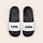 Black personalized sliders with white straps printed with the name John and the year 1996