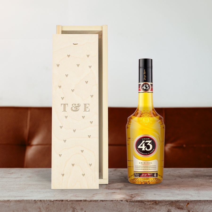 Licor 43 liqueur in an engraved wooden case with T&E initials and heart patterns, ready to surprise your loved ones.