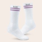 A pair of white personalised sports socks with lilac stripes, customized with the name Scott printed on each sock.