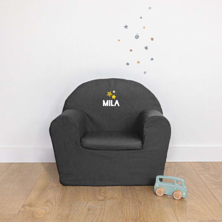Cute black toddler chair with the name Mila and yellow stars printed on the backrest
