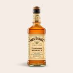 A bottle of Jack Daniels Honey whisky in an engraved wooden case