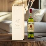 Jameson whisky bottle next to an engraved wooden case with the text Dean and a bow design