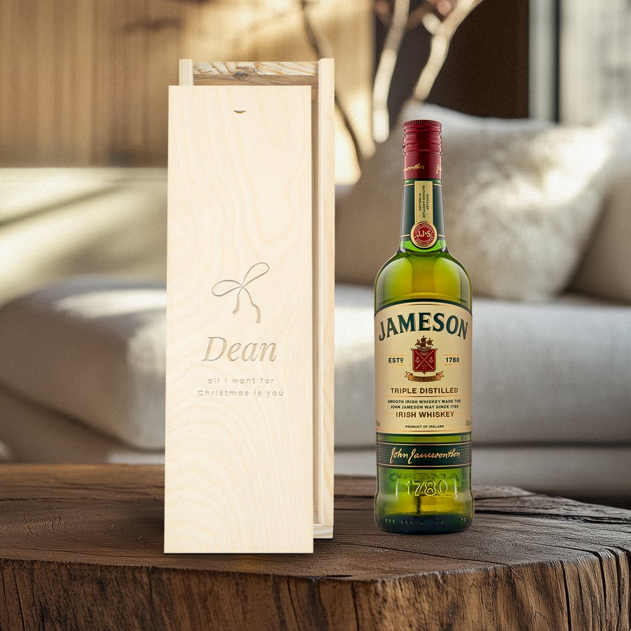 Jameson whisky bottle next to an engraved wooden case with the text Dean and a bow design