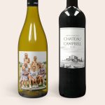 White and red wine bottles with personalised labels. The white wine label features a photo of a family, while the red wine label displays a vintage Chateau design.