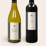 Two wine bottles, one white and one red, with personalized labels. The white wine label says "Cheers David" and the red says "5 year." Both labels feature a small logo area. This is a great wine gift set.