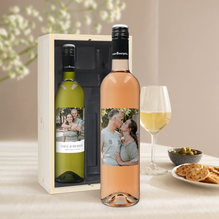 Two bottles of Maison de la Surprise wine in a wooden gift box with personalized labels featuring photos of couples.