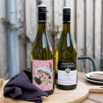 Two Chardonnay bottles with a personalized label, one showing a couple's photo and the other the wine brand.