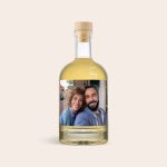 Bottle of whisky with a custom photo label featuring a smiling couple. This personalized whisky makes a unique gift.
